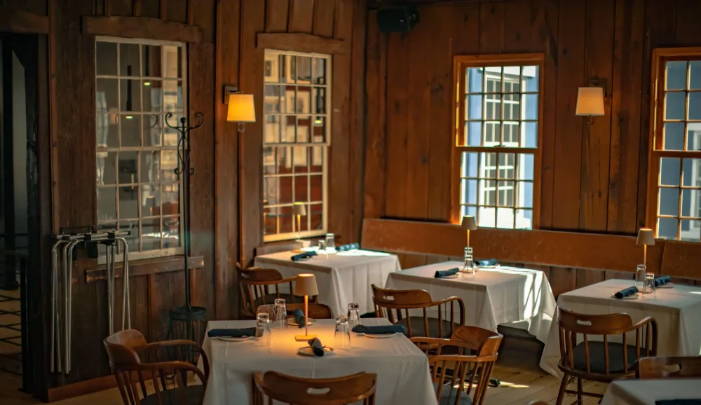 Warm timber dining room set for a gathering at The Brushmill by the Waterfall